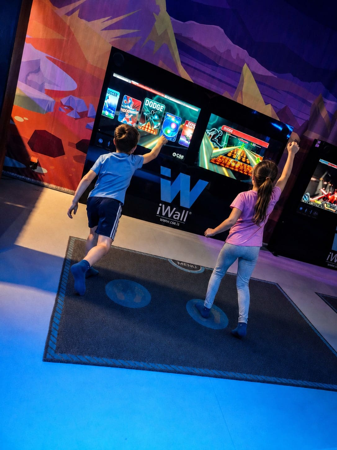 Kinder beim Bewegungsspiel an den interaktiven iWall-Bildschirmen